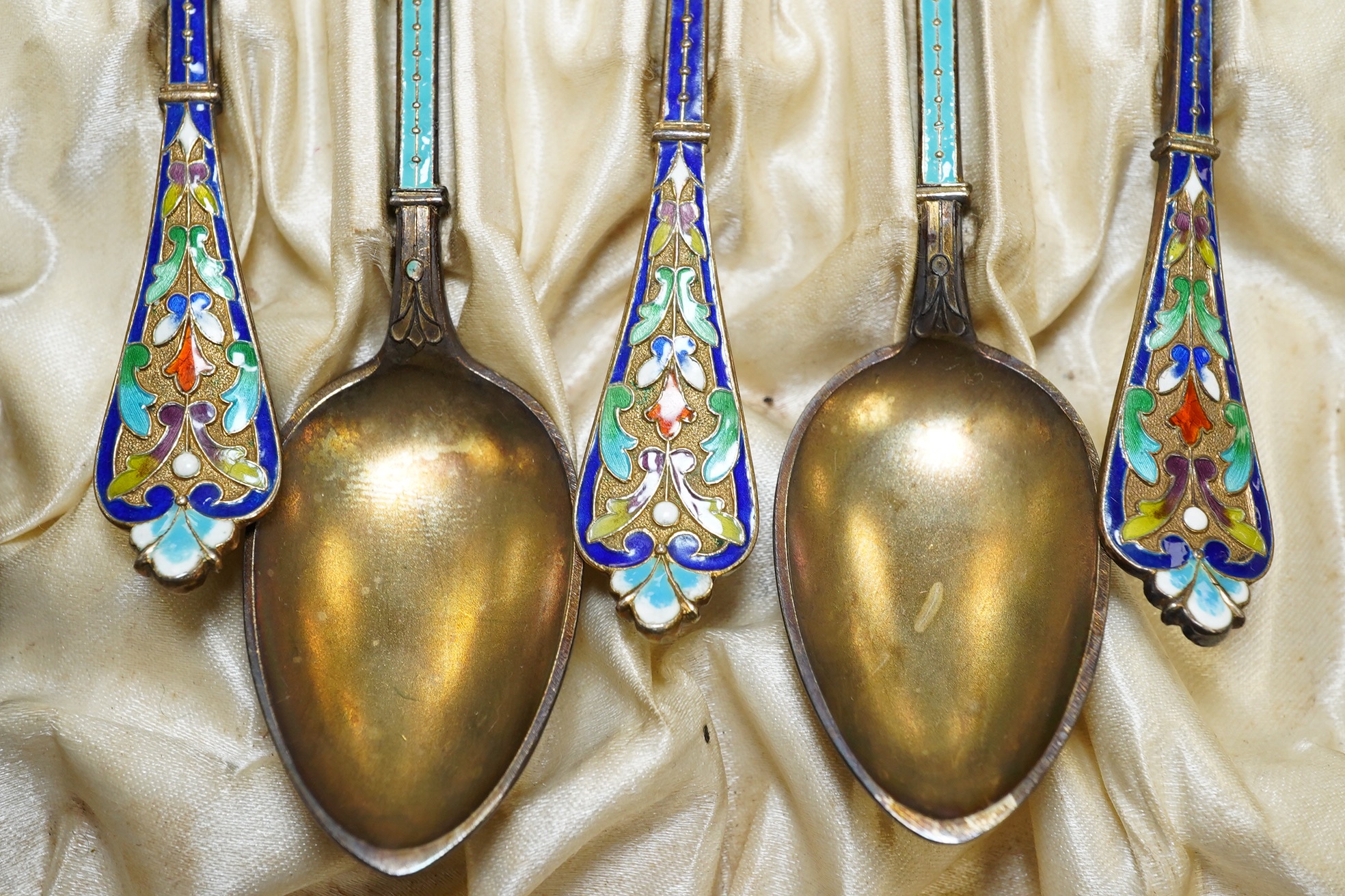 Two sets of Norwegian six enamelled gilt metal and cloisonné enamelled teaspoons, 11.9cm. Condition - poor to fair